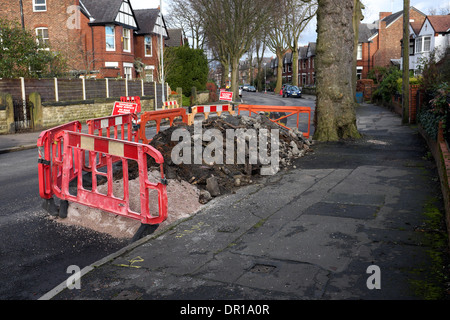 Le macerie da lavori stradali lungo una strada suburbana Foto Stock