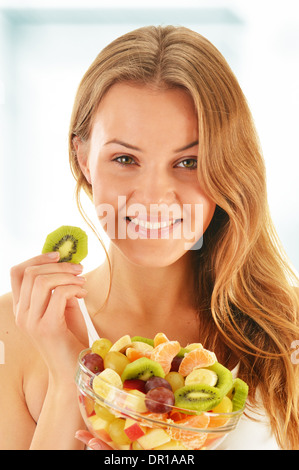 Giovane donna di mangiare insalata di frutta