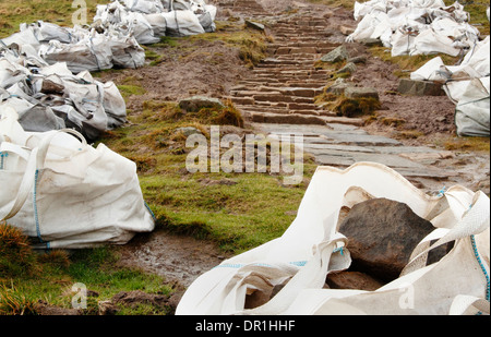 Riparazione di pietra erosa sentiero in corso sul Mam Tor, un popolare percorso pedonale vicino a Castleton, Peak District, Derbyshire, Regno Unito Foto Stock