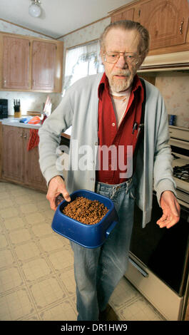 Novembre 25, 2008, Escondido, CALIFORNIA, STATI UNITI D'AMERICA 79 anni CALKINS JACK porta una ciotola ha appena riempito con alimento di gatto per i suoi due gatti, Tigger e Mama. Il cibo è consegnata a lui da Animeals, un programma da Helen Woodward Centro animale Credit: Foto di Charlie Neuman, San Diego Union-Tribune/Zuma premere. copyright 2008 San Diego Union-Tribune (credito Immagine: © Il San Diego Unio Foto Stock