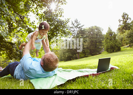 Padre giocando con la bambina in posizione di parcheggio Foto Stock