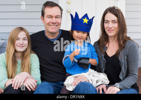 Famiglia insieme sorridente al di fuori casa Foto Stock