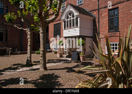 Ingresso porticato, porta & cortile in ciottoli del centro storico di Grado 1 edificio elencato - Grigio Court Hotel & Restaurant, York, North Yorkshire, Inghilterra, Regno Unito. Foto Stock