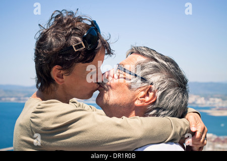Donna di mezza età e senior Uomo in amore kissing all'esterno. Foto Stock