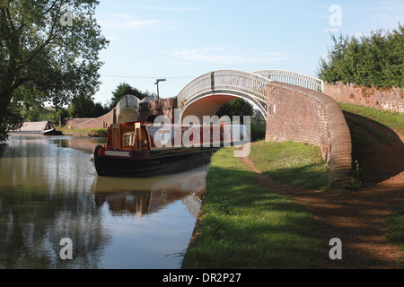 Un narrowboat sulla Oxford Canal sotto il ponte doppio di Braunston a sua volta il Grand Union Canal andando fuori a sinistra Foto Stock