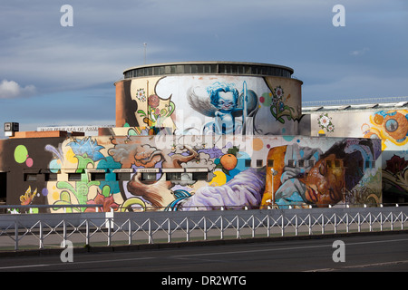 Grafities su un lato posteriore di una stazione degli autobus nel centro della città di Siviglia, Spagna. Foto Stock