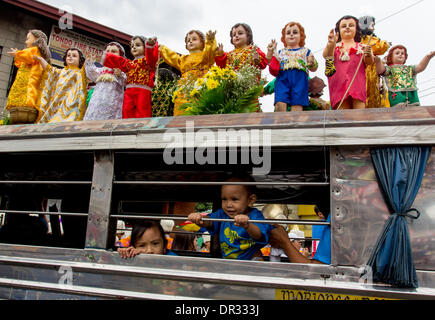 Metro Manila, Filippine - 18 Gennaio 2014: i bambini all'interno di un veicolo passeggeri e in cima sono state le immagini di Gesù Bambino che indossa costome diverse, "Lakbayaw" è festa dai Tagalog parole, 'Lakbay " (viaggio) e 'Sayaw" (danza) nell'area urbana di Tondo, Manila che unifica quasi tutte le organizzazioni, scuole, gruppi di comunità e la gente di Tondo come parte della loro devozione al Santo Nino.Filippine è il solo Cattolico Romana Nazione nel sud-est asiatico con circa 93 percento di praticare la fede. Credito: Herman Lumanog/Alamy Live News Foto Stock