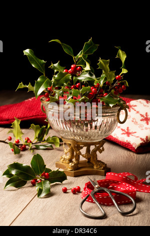 Decorazione per il Natale con antichi vaso pieno di agrifoglio e bacche Foto Stock