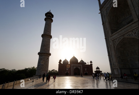 Persone e il Taj Mahal contro il sole del tardo pomeriggio Foto Stock