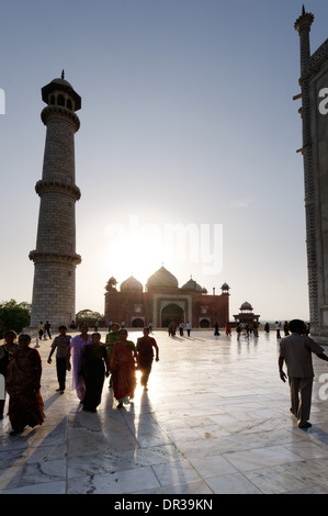 Persone e il Taj Mahal contro il sole del tardo pomeriggio Foto Stock