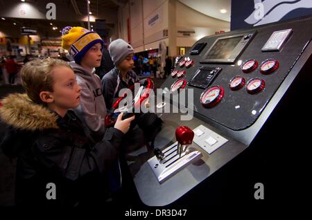 Toronto, Canada. Xix gen, 2014. Kids provare la guida di un pannello di controllo sul display durante il 2014 Toronto International Boat Show a energia diretta centro di Exhibition Place a Toronto, Canada, Gennaio 18, 2014. Come uno dei più grandi consumatori barca mostra in Nord America e in questo caso espone più di mille i nuovi modelli di imbarcazioni e motori sul mercato da Gen 11 al 19 gen. Credito: Zou Zheng/Xinhua/Alamy Live News Foto Stock