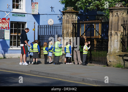 Classe scolastica visitando la chiesa di San Giovanni Battista, Glastonbury High Street, Somerset, Inghilterra Foto Stock