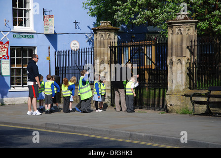 Classe scolastica visitando la chiesa di San Giovanni Battista, Glastonbury High Street, Somerset, Inghilterra Foto Stock