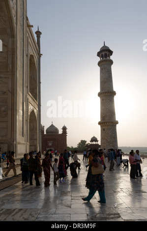 Persone e il Taj Mahal contro il sole del tardo pomeriggio Foto Stock