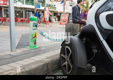 Renault Twizy alimentato a batteria auto elettrica inserita in un sol-lar la carica della batteria punto sulla strada in Isole Canarie Foto Stock