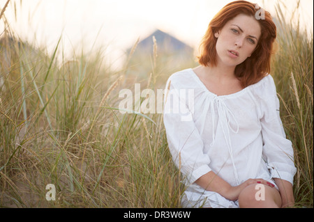 Rilassata estate Ritratto di giovane caucasico dai capelli rossi donna in erba lunga Foto Stock