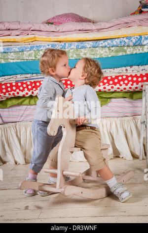 I bambini giocano con un legno giocattolo a dondolo Pony cavallo. Foto Stock