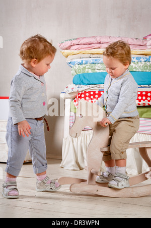 I bambini giocano con un legno giocattolo a dondolo Pony cavallo. Foto Stock