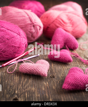 Crochet Cuori rosa e di filati su sfondo di legno Foto Stock