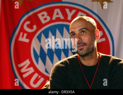 Josep "" Pep Guardiola, allenatore di calcio tedesco Bundesliga Club FC Bayern Monaco di fronte al logo del club Foto Stock