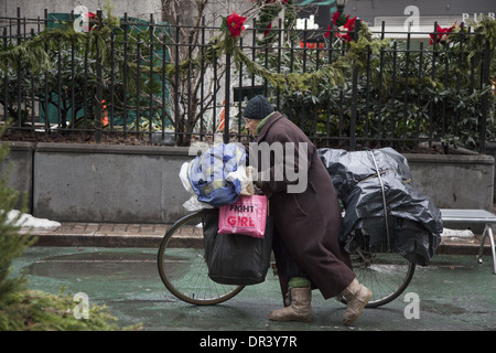Vecchia donna rende il suo modo di Broadway con tutti i suoi possedimenti sulla sua bicicletta in New York City. Foto Stock