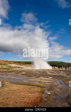 Gruppo di turisti a guardare un Eruzione del geyser Strokkur in Haukadalur, Islanda. Foto Stock