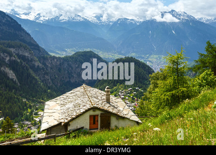 Estate paesaggio di montagna con la neve sul monte alto e casa sulla pendenza (Alpi, Svizzera) Foto Stock