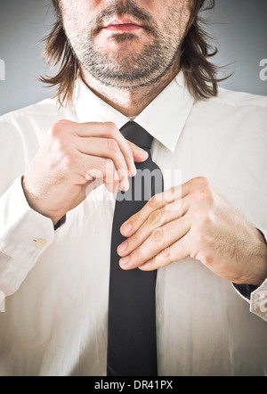 Imprenditore cravatta di legatura. Uomo di correggere il tirante, close up con il fuoco selettivo. Foto Stock