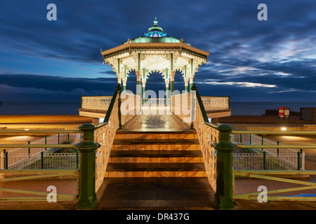 Bandstand illuminato lungo il lungomare di Brighton al tramonto Foto Stock