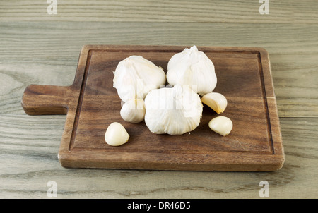 Foto orizzontale di fresco aglio crudo sul noce nero con bordo legno invecchiato sotto Foto Stock