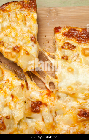 Afferrando la prima fetta di formaggio pizza Foto Stock