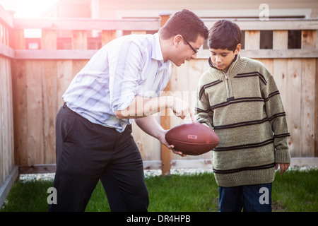 Ispanico padre figlio di insegnamento per il gioco del calcio Foto Stock