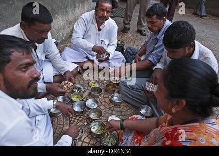 Mar 03, 2009 - Mumbai, Maharashtra, India - BABAN KADAM, insieme al compagno dabbawallas, avente il pranzo dopo la consegna del pranzo riempite le caselle per l'ufficio del client. Dopo pranzo comincia il suo viaggio di ritorno sollevando il vuoto scatole pranzo presso gli uffici dei clienti di essere consegnati alle loro case. (Credito Immagine: © Subhash Sharma/ZUMApress.com) Foto Stock