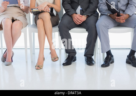 Sezione bassa di persone in attesa per il colloquio di lavoro in ufficio Foto Stock