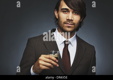 Closeup ritratto di attraente giovane nel business suit tenendo una tazza di caffè in mano. Maschio asiatici business executive Foto Stock