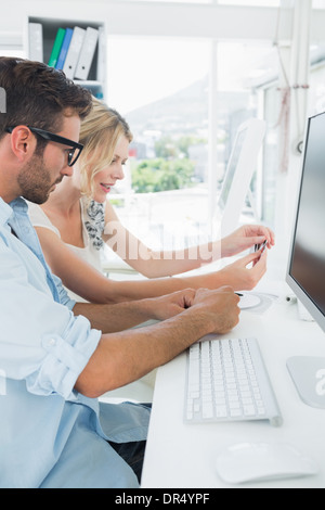 Sorridente casual coppia giovane lavorando sul computer Foto Stock