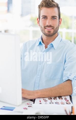 Ritratto di un sorridente giovane utilizzando il computer Foto Stock