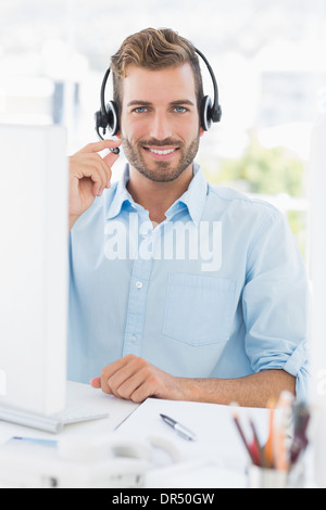 Ritratto di un giovane Casual Uomo con cuffie utilizzando il computer Foto Stock