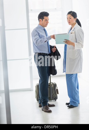 Medico e imprenditore parlando in ospedale Foto Stock