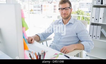 Ritratto di un sorridente giovane utilizzando il computer Foto Stock