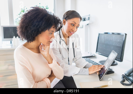 Americano africano il medico e il paziente parla in office Foto Stock