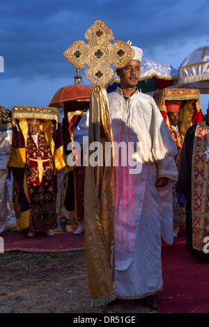 Addis Abeba, etiope . 18 gennaio, 2014. Un sacerdote che porta una grande croce davanti al suo compagno di ecclesiastici che trasportano Tabots, un modello di arco di alleanza, durante la sfilata di Timket celebrazioni dell Epifania, che commemora il battesimo di Gesù, il 18 gennaio 2014 ad Addis Abeba. Credito: Dereje Belachew/Alamy Live News Foto Stock