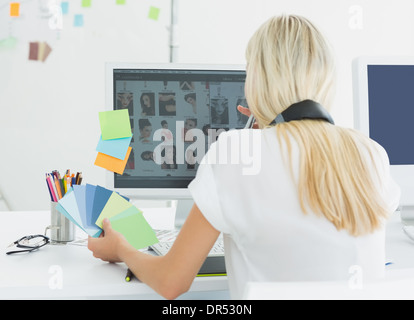 Vista posteriore di una donna informale utilizzando computer in ufficio Foto Stock
