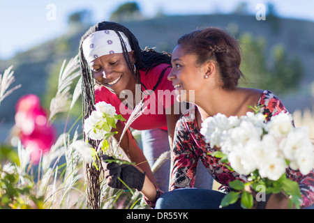 Madre e figlia a caccia di fiori all'aperto Foto Stock