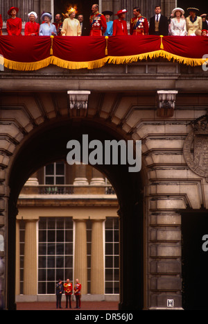 Mentre gli ufficiali stand in un quadrangolo della Gran Bretagna la famiglia reale appaiono sul balcone a Buckingham Palace. Foto Stock