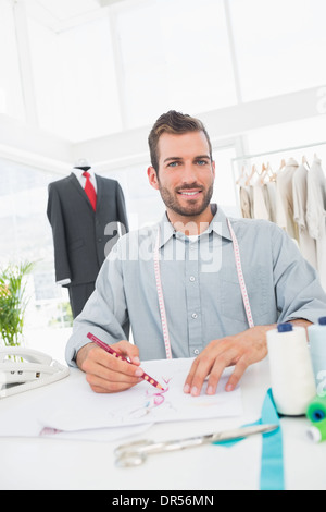 Fashion designer che lavora sui suoi disegni in studio Foto Stock