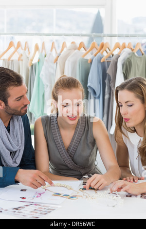 Tre disegnatori di moda a discutere di progetti Foto Stock
