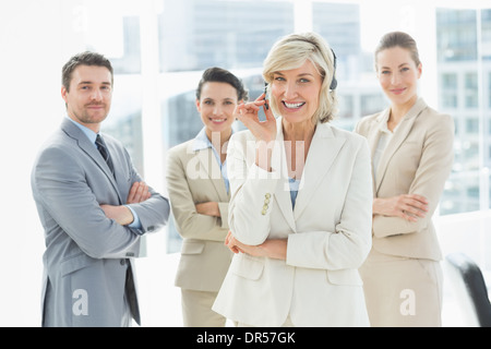 Coppia imprenditrice che indossa la cuffia con i colleghi in ufficio Foto Stock