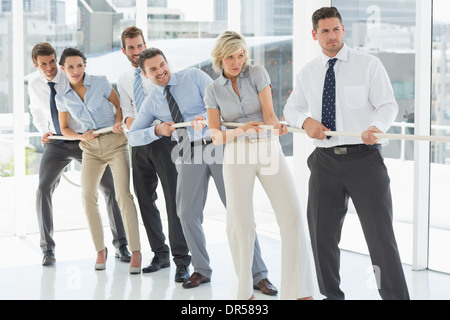 Un gruppo di uomini di affari che tirando la corda in ufficio Foto Stock