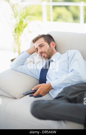 Ben vestito uomo a guardare la tv in soggiorno Foto Stock